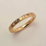 18ct rose gold ring with roman set blue and white diamonds.